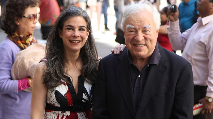 Arthur Frommer, de 83 años, y su hija, Pauline Frommer, de 46, posan entre turistas en el área de Wall Street en Nueva York, el 20 de mayo de 2012. (Foto AP/Seth Wenig, Archivo)