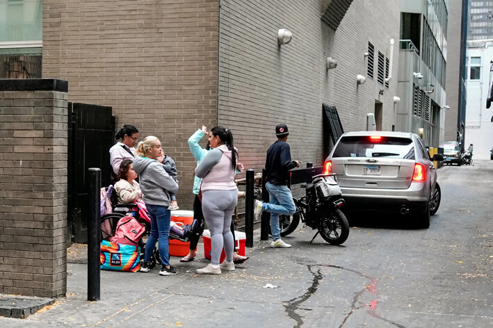 Un grupo de inmigrantes ilegales en un callejón frente al hotel Inn of Chicago, el 22 de octubre de 2024. (Steven Kovac/Epoch Times)