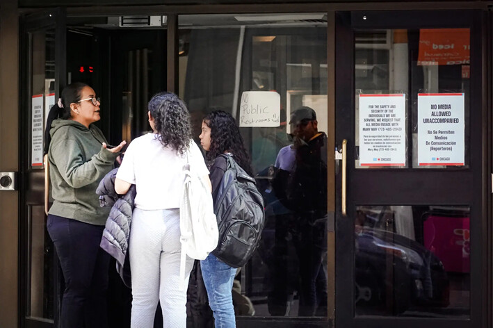 Personas llegan al Inn of Chicago, un hotel en el centro de la ciudad que aloja temporalmente a inmigrantes ilegales recién llegados, el 10 de mayo de 2023. (Scott Olson/Getty Images)