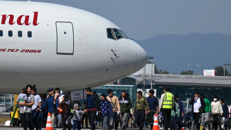 Guatemaltecos deportados de Estados Unidos caminan por la pista tras aterrizar en una base de la Fuerza Aérea Guatemalteca en Ciudad de Guatemala en el primer vuelo de deportados del año el 3 de enero de 2024. (Johan Ordonez/AFP)
