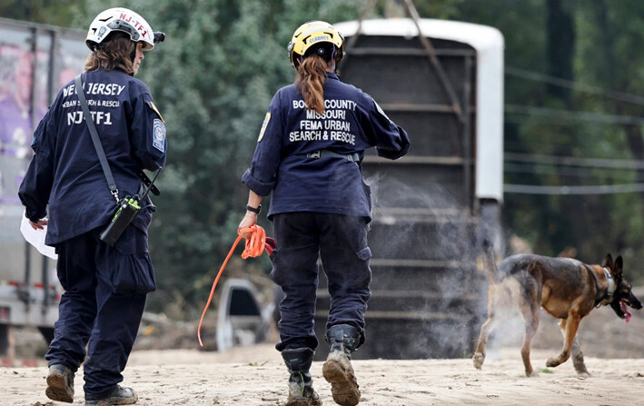 Miembros del Grupo de Trabajo de Búsqueda y Rescate Urbano de FEMA buscan con un perro de búsqueda en un área afectada por las inundaciones después del huracán Helene a lo largo del río Swannanoa, en Asheville, Carolina del Norte, el 4 de octubre de 2024. (Mario Tama/Getty Images)