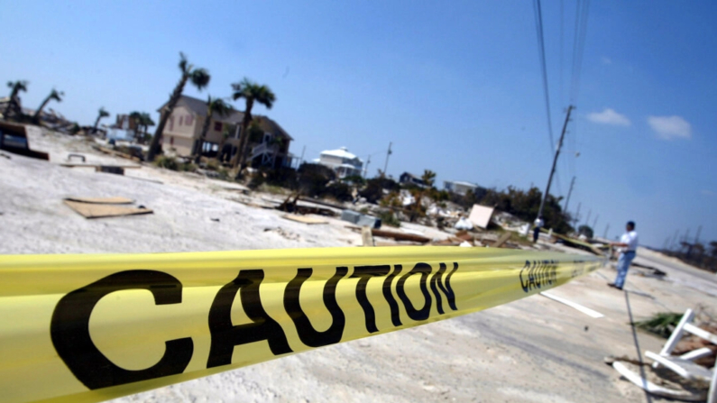 Agentes de policía de Orange Beach colocan cinta de precaución cerca de un edificio derrumbado en Orange Beach, Alabama, el 18 de septiembre de 2004. (Justin Sullivan/Getty Images)