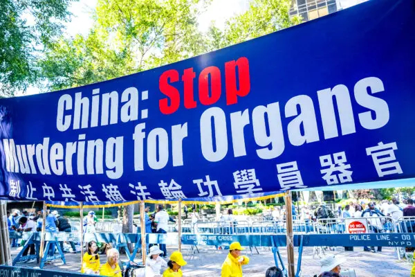 Una pancarta pidiendo el fin de la sustracción forzada de órganos de los practicantes de Falun Gong en China se muestra mientras los practicantes hacen una demostración de la meditación de esta práctica espiritual, junto a las Naciones Unidas en Nueva York, el 20 de septiembre de 2023. (Chung I Ho/The Epoch Times)