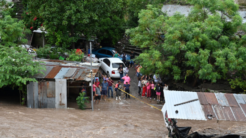 La gente observa la crecida del río Choluteca en Tegucigalpa (Honduras) el 17 de noviembre de 2024, debido a las fuertes lluvias dejadas por la tormenta tropical Sara. (Orlando Sierra/AFP vía Getty Images)