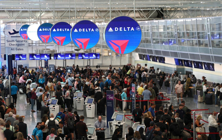 Los pasajeros esperan en fila debido a problemas de software que retrasaron vuelos a nivel mundial en Minneapolis, en el Aeropuerto Internacional Minneapolis-St. Paul, el 19 de julio de 2014. (AP Photo/Adam Bettcher)