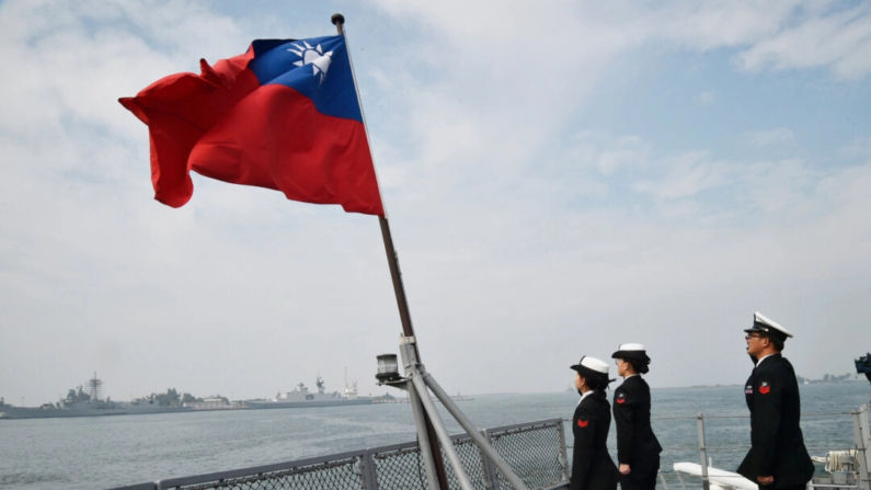 Marineros taiwaneses saludan a la bandera de la isla en la cubierta del buque de suministros Panshih tras participar en ejercicios anuales, en la base naval de Tsoying en Kaohsiung, Taiwán, el 31 de enero de 2018. (Mandy Cheng/AFP vía Getty Images)