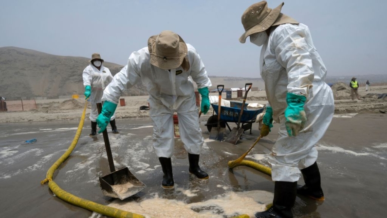 Cuadrillas de limpieza trabajan para retirar petróleo de la Playa Cavero en Callao, Perú, el 26 de enero de 2022. (Cris Bouroncle/AFP vía Getty Images)