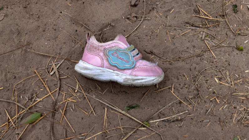 Un zapato abandonado de una niña yace cerca de un punto de cruce ilegal en el río en la frontera entre EE. UU. y México el 24 de marzo de 2021 en McAllen, Texas. (John Moore/Getty Images)