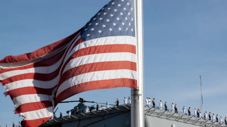 Una bandera estadounidense se ve mientras los marines y marineros de la Armada del USS Bataan están de pie en la cubierta del navío a la llegada para la Semana de la Flota 2022 en la ciudad de Nueva York el 25 de mayo de 2022. (Alexi J. Rosenfeld/Getty Images)