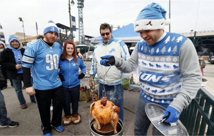 Un aficionado de los Lions revisa un pavo de Acción de Gracias mientras hace cola antes de un partido entre los Detroit Lions y los Chicago Bears en Detroit el jueves 27 de noviembre de 2014. (Paul Sancya/Foto AP)