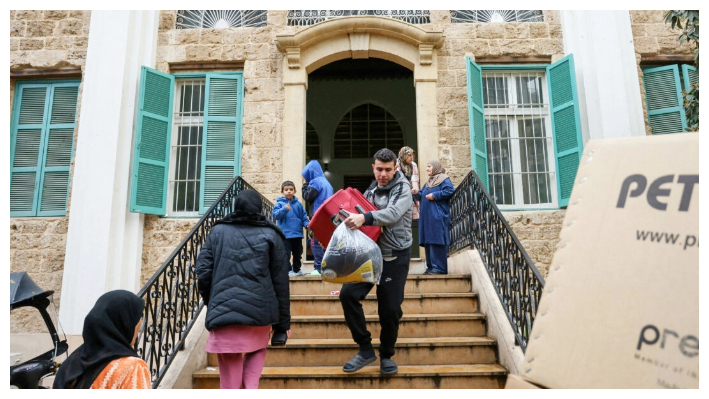 Desplazados llevan sus pertenencias al salir de una escuela convertida en refugio en Beirut, Líbano, el 27 de noviembre de 2024, mientras las personas regresan a sus hogares tras la entrada en vigor de un alto el fuego entre Israel y Hezbolá. (Ibrahim Ambro/AFP vía Getty Images)