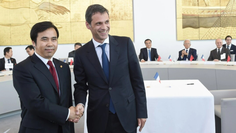 Liu Liange (izq.), vicepresidente del Banco de Exportación e Importación de China, estrecha la mano de Rodolphe Saade, vicepresidente de la empresa francesa de transporte y envío de contenedores CGA-CGM, durante la ceremonia de firma de un contrato en Marsella, Francia, el 1 de julio de 2015. (Boris Horvat/AFP vía Getty Images)
