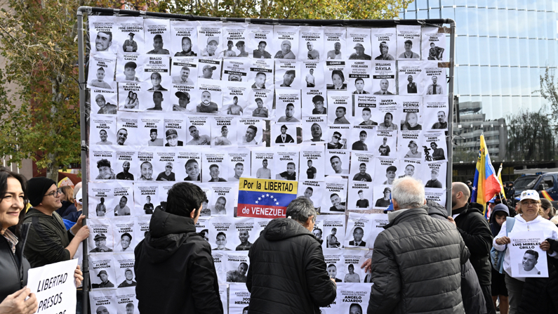 Un cartel muestra fotografías de presos políticos en Venezuela durante la manifestación de opositores políticos venezolanos que ha tenido lugar este domingo en Madrid. (EFE/ Victor Lerena)