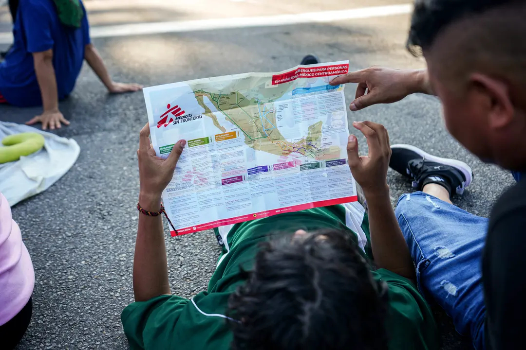 Migrantes, que forman parte de una caravana que se dirige hacia Estados Unidos, consultan un mapa durante un descanso en las afueras de Escuintla, México, el 7 de noviembre de 2024. (Moises Castillo/Foto AP)