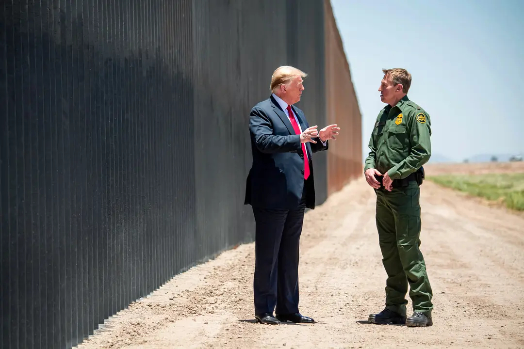 El presidente Donald Trump habla con el jefe de la Patrulla Fronteriza de Estados Unidos, Rodney Scott, mientras participan en una ceremonia conmemorativa de la milla 200 del muro fronterizo en San Luis, Arizona, el 23 de junio de 2020. (Saul Loeb/AFP vía Getty Images)