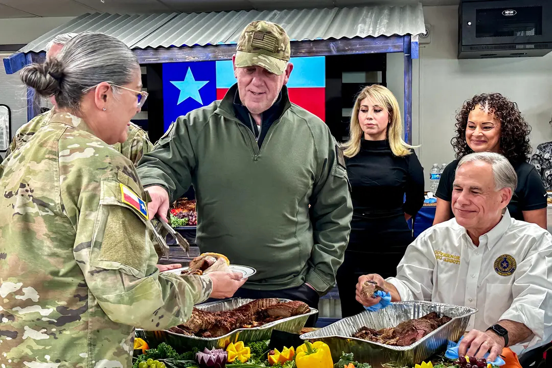 El zar fronterizo entrante Tom Homan (C) y el gobernador de Texas Greg Abbott (D) sirven comida al personal de Texas desplegado en la frontera sur, en Eagle Pass, Texas, el 26 de noviembre de 2024. (Darlene McCormick Sanchez/The Epoch Times)