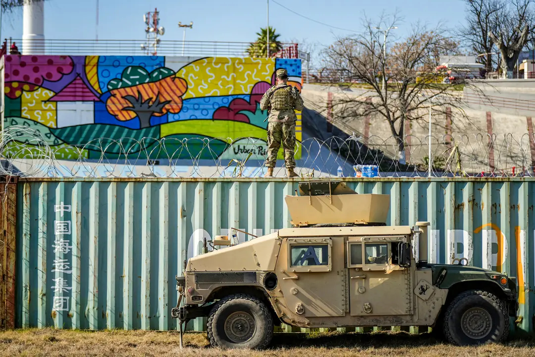 Un miembro de la Guardia Nacional de Texas se encuentra en un contenedor de transporte que actúa como barrera fronteriza junto a la frontera entre Estados Unidos y México en Eagle Pass, Texas, el 3 de enero de 2024. (Charlotte Cuthbertson/The Epoch Times)