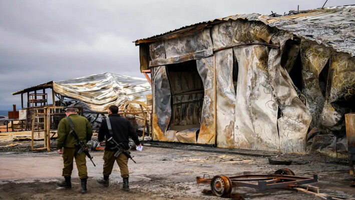 Soldados israelíes caminan junto a una granja de animales dañada por un cohete disparado desde Líbano en Avivim, norte de Israel, cerca de la frontera con Líbano, el 27 de noviembre de 2024. (Francisco Seco/Foto AP)