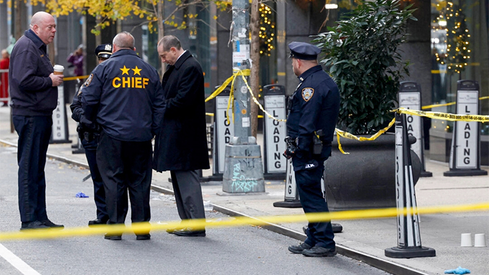 Oficiales de policía cerca del lugar donde Brian Thompson, director ejecutivo de UnitedHealthcare, fue tiroteado y asesinado en Midtown Manhattan, en Nueva York, el 4 de diciembre de 2024. (Shannon Stapleton/Reuters)