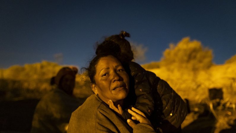 Contenido gráfico / Sulan, una mujer migrante de Venezuela, es consolada por su hija mientras llora al relatar su travesía para llegar a El Paso, Texas, el 2 de abril de 2024. (CHRISTIAN MONTERROSA/AFP via Getty Images)