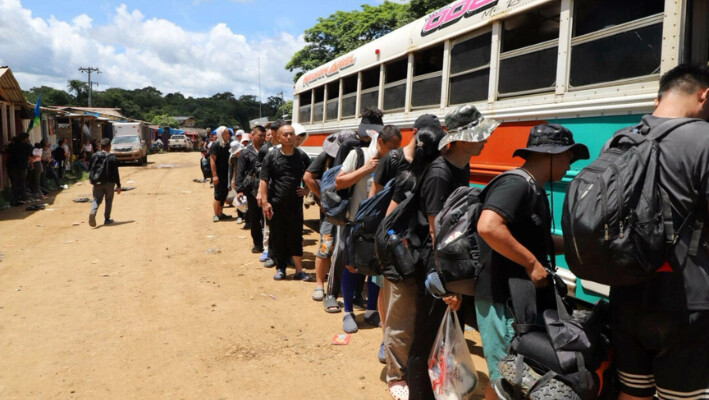 Inmigrantes ilegales chinos en el campamento Canaán Membrillo suben a un autobús para la siguiente etapa de su viaje a la frontera sur de EE.UU., en Panamá, el 3 de julio de 2024. (Oscar Ramirez para The Epoch Times).