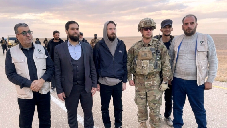 Esta imagen facilitada por Mouaz Moustafa muestra a Travis Timmerman, en el centro, junto a un miembro del ejército estadounidense y representantes del gobierno de transición de Siria y activistas de la oposición cerca de la frontera entre Siria y Jordania el 13 de diciembre de 2024. (Mouaz Moustafa vía AP)
