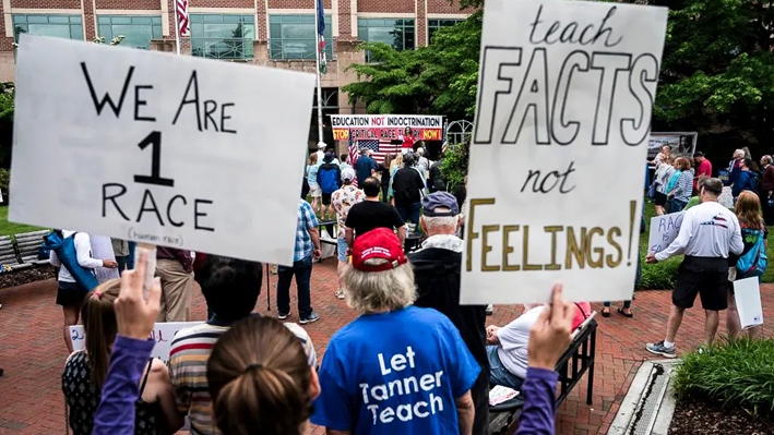 Manifestantes sostienen carteles durante una protesta contra la «teoría crítica de la raza» (TCR) que se enseña en las escuelas en el centro de Gobierno del Condado de Loudoun, en Leesburg, Virginia, el 12 de junio de 2021. (Andrew Caballero-Reynolds/AFP vía Getty Images)