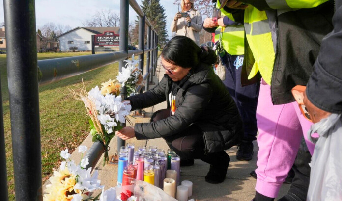 Un residente coloca algunas flores afuera de la Escuela Cristiana Abundant Life en Madison, Wisconsin, el 17 de diciembre de 2024, luego de un tiroteo el 16 de diciembre. (Morry Gash/AP Foto)