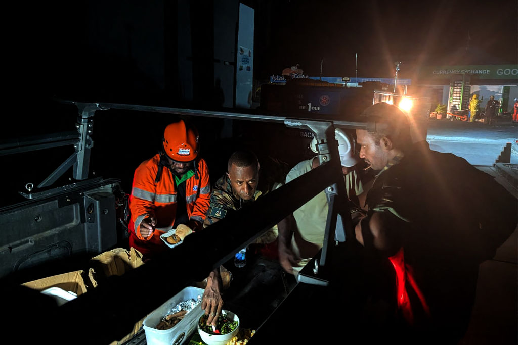 Los equipos de rescate toman un descanso para comer en el lugar donde se derrumbó un edificio tras el terremoto que sacudió Port Vila, la capital de Vanuatu, el 18 de diciembre de 2024. (STR/AFP vía Getty Images)