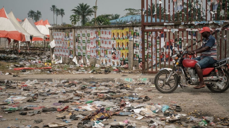 Un ciclista circula junto a zapatos y objetos tirados en el suelo tras una estampida en Port Harcourt, sur de Nigeria, en una imagen de archivo. (Yasuyoshi Chiba/AFP vía Getty Images)