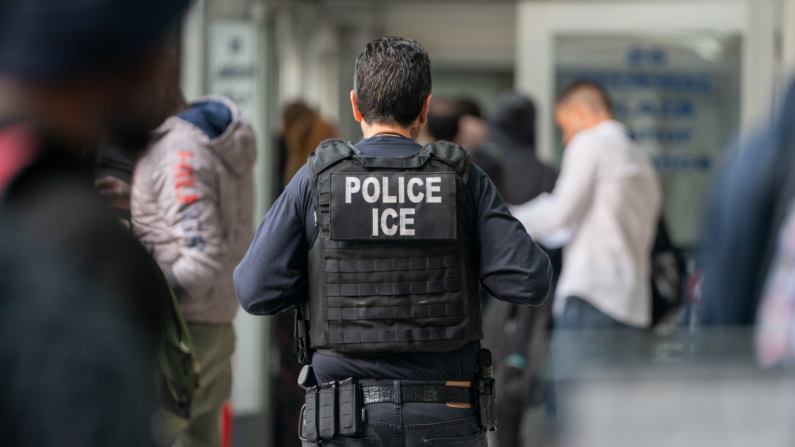 Un agente de ICE supervisa a cientos de solicitantes de asilo que están siendo procesados al ingresar al edificio federal Jacob K. Javits el 6 de junio de 2023 en la ciudad de Nueva York. (David Dee Delgado/Getty Images)