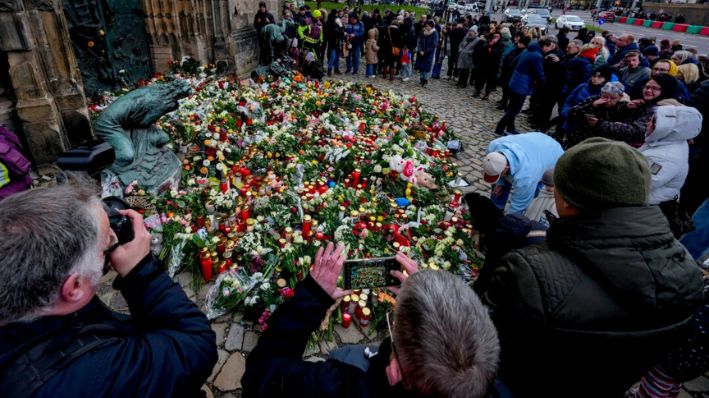 Un grupo de personas deposita flores a la entrada de una iglesia cerca de un mercado navideño, donde un coche arrolló a una multitud el viernes por la noche, en Magdeburgo, Alemania, el sábado 21 de diciembre de 2024. (Michael Probst/Foto AP)