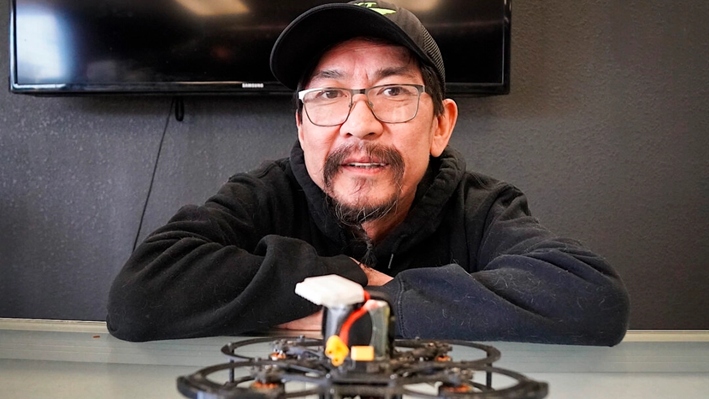 Pete Phimphavong, propietario de Rekt Drones en Mesa, Arizona, muestra un popular dron de carreras en su tienda, el 18 de diciembre de 2024. (Allan Stein/The Epoch Times)