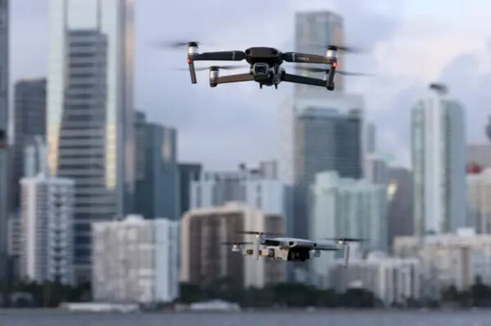 Drones chinos DJI Mavic 2 Pro y un DJI Mavic Mini vuelan uno cerca del otro en Miami, Florida, el 15 de diciembre de 2021. (Joe Raedle/Getty Images)