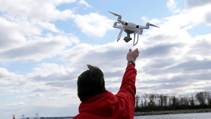 Un operador de drones ayuda a recuperar un dron después de fotografiar sobre Hart Island, en Nueva York, el 29 de abril de 2018. (Seth Wenig/Foto AP)