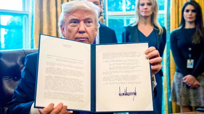 El presidente Donald Trump sostiene una de las órdenes ejecutivas que firmó para reactivar la construcción del oleoducto Keystone XL y otro oleoducto que atraviesa Dakota del Norte, en el Despacho Oval de la Casa Blanca, el 24 de enero de 2017. (Nicholas Kamm/AFP vía Getty Images)