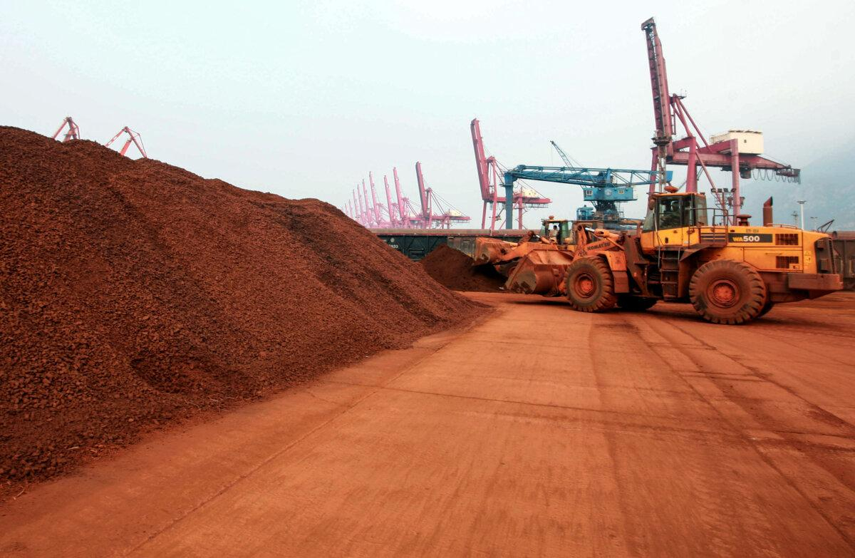 Un cargador desplaza tierra que contiene minerales de tierras raras para cargarla en un puerto de Lianyungang, en la provincia china de Jiangsu, el 5 de septiembre de 2010. (STR/AFP vía Getty Images)