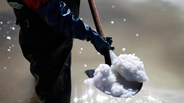 Un trabajador utiliza una pala para mostrar la materia prima para la fabricación de carbonato de litio dentro de una piscina de recuperación de sal en la Planta Piloto de Llipi en el Salar de Uyuni en Bolivia el 13 de agosto de 2022. El Salar de Uyuni, en la provincia de Potosí, cuenta con las mayores reservas de litio del mundo. (Gaston Brito Miserocchi/Getty Images)