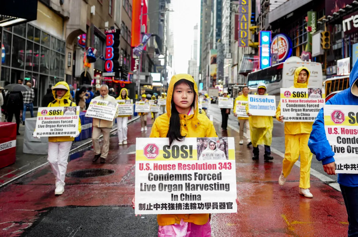 Practicantes de Falun Gong participan en un desfile en la ciudad de Nueva York el 10 de mayo de 2024 para celebrar el Día Mundial de Falun Dafa mientras piden el fin de la persecución de esta práctica espiritual en China. Las pancartas que sostienen conciencian sobre la sustracción forzada de órganos sancionada por el Estado chino, que afecta principalmente a los practicantes de Falun Gong. (Samira Bouaou/The Epoch Times)