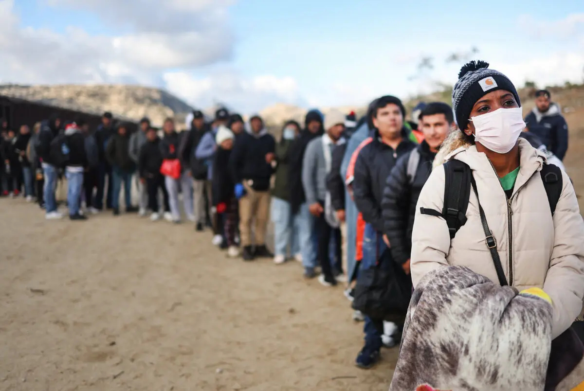 Inmigrantes ilegales a lo largo de la frontera entre EE. UU. y México a la espera de ser procesados por la Patrulla Fronteriza de EE. UU. en Jacumba Hot Springs, California, el 1 de diciembre de 2023. (Mario Tama/Getty Images)