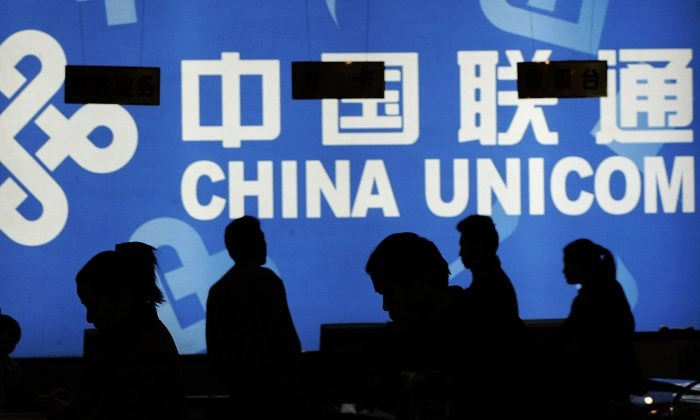 Unos clientes miran productos en una tienda de China Unicom en Beijing el 9 de noviembre de 2004. Recientemente, investigadores del Partido Comunista descubrieron un nepotismo generalizado en la empresa. (Peter Parks/AFP/Getty Images).