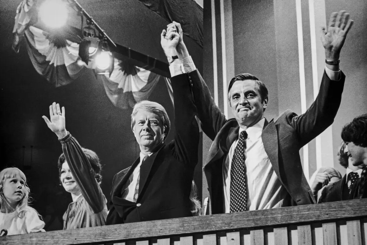 El candidato demócrata a la presidencia Jimmy Carter levanta la mano junto al candidato a la vicepresidencia Walter Mondale (d) en la Convención Nacional Demócrata en Nueva York el 15 de julio de 1976. La esposa de Carter, Rosalynn, y su hija Amy, saludan a su lado. (Archivo Hulton/Getty Images)