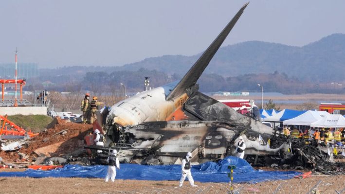 Bomberos y miembros del equipo de rescate trabajan cerca de los restos de un avión de pasajeros en el Aeropuerto Internacional de Muan en Muan, Corea del Sur, el 29 de diciembre de 2024. (Ahn Young-joon/AP Photo)