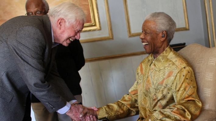 Nelson Mandela (derecha) se reúne con Jimmy Carter mientras otros miembros de los Elders observan en Johannesburgo, Sudáfrica, el 29 de mayo de 2010. (Jeff Moore vía Getty Images)