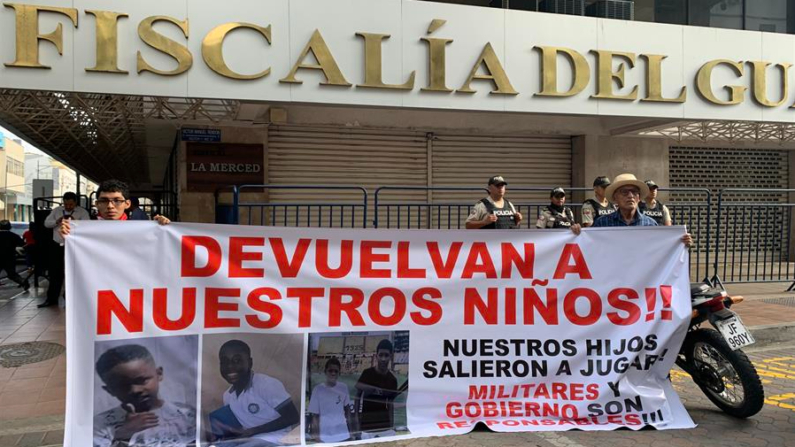 Fotografía del 23 de diciembre de 2024 que muestra a familiares de los menores desaparecidos con un cartel en los exteriores de la Fiscalía Provincial del Guayas en Guayaquil (Ecuador). EFE/Cristina Bazán