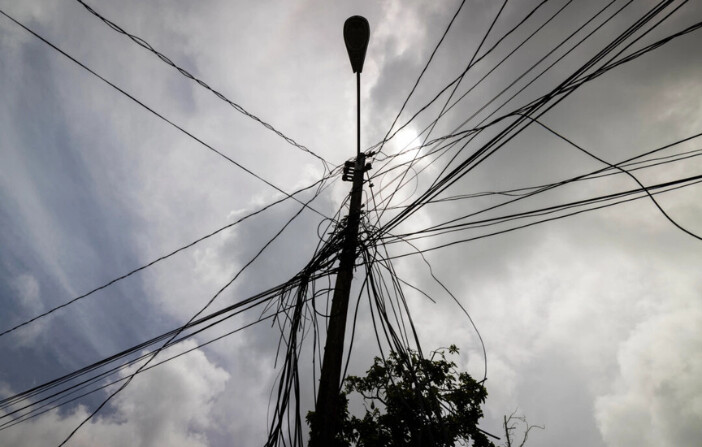 Un poste de servicios públicos con cables sueltos se eleva sobre una casa en Loiza, Puerto Rico, 15 de septiembre de 2022. (Alejandro Granadillo/Foto AP).
