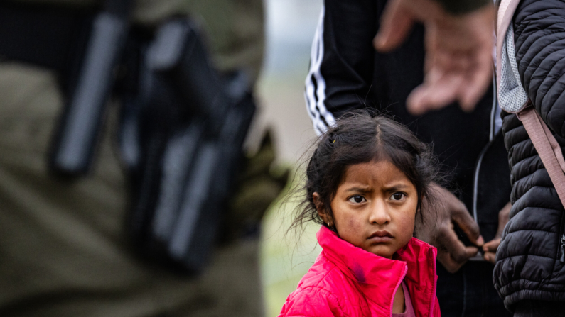 Una niña migrante espera ser procesado por agentes de la Patrulla Fronteriza en Otay Mesa, California, el 29 de febrero de 2024.(John Fredricks/The Epoch Times)