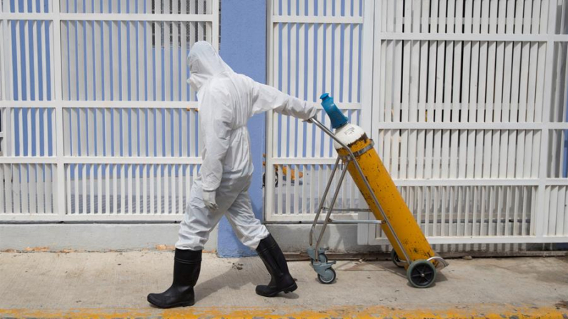 Imagen de archivo de un trabajador médico que transporta un cilindro. EFE/ Orlando Barría
