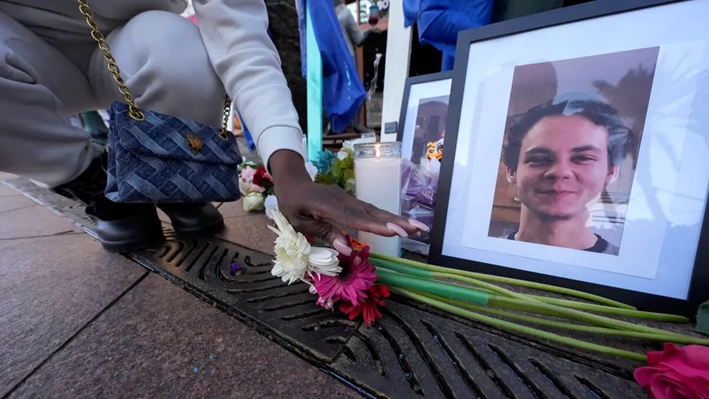 Una mujer coloca flores junto a fotos de la víctima Matthew Tenedorio en un monumento en Canal Street para las víctimas de un ataque mortal con un camión el día de Año Nuevo, en Nueva Orleans, el 3 de enero de 2025. (Gerald Herbert/AP Photo)