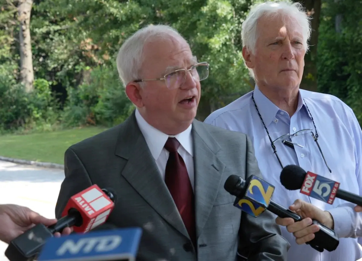 John Eastman (I), exabogado y asesor del expresidente Donald Trump, habla con los periodistas junto a su abogado, L. David Wolfe, a las puertas de la cárcel del condado de Fulton el 22 de agosto de 2023, en una imagen de un video. (NTD/Captura de pantalla vía The Epoch Times)